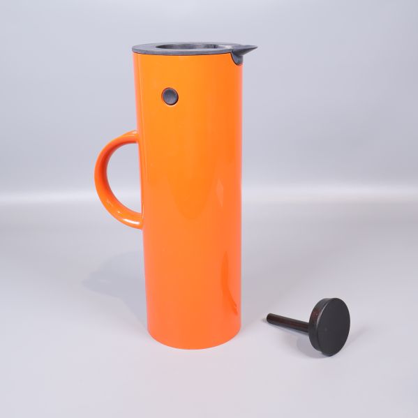 Termos bredvid sitt svarta lock placerat på sidan