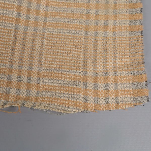 Närbild på tygkant med fransar och rutigt mönster