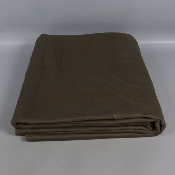 Sammanslaget grå grönt filttyg på grå yta