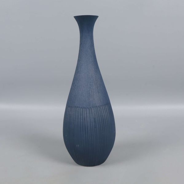 Vas i blått sedd rakt framifrån mot grå bakgrund