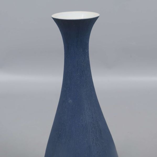 Närbild på vasens hals med matt blå yta