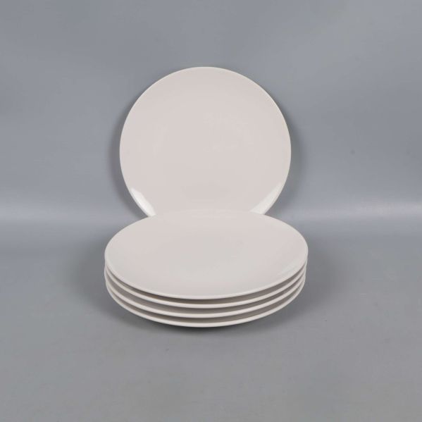 Fem staplade vita tallrikar mot grå bakgrund