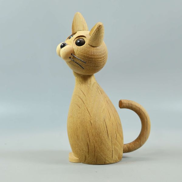 Träfigur av katt från vänster sida, svansen synlig