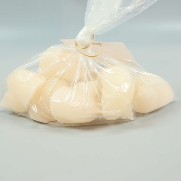 Snäckformade ljus i genomskinlig plastpåse liggande på bord