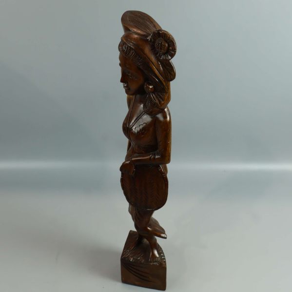 Profilbild av tribalinspirerad träskulptur på ljus bakgrund