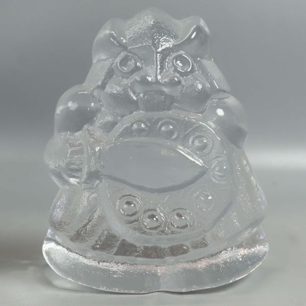 Glasfigur av samurai rakt framifrån mot ljus bakgrund