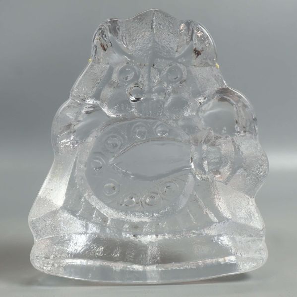 Glasfigur av samurai rakt bakifrån mot ljus bakgrund