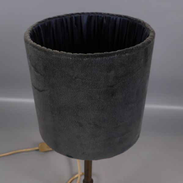 Närbild på grå cylinderformad lampskärm i sammet
