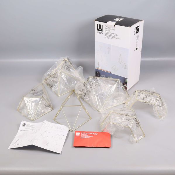 Sex geometriska figurer i plastpåsar framför kartong