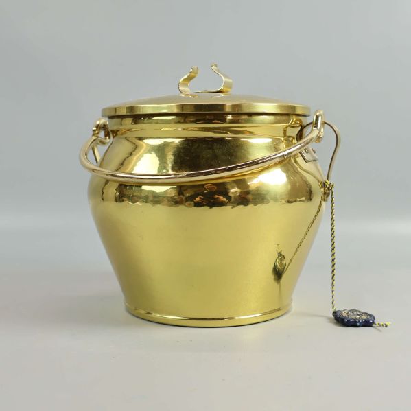 Glansig gyllene metallburk med lock och handtag