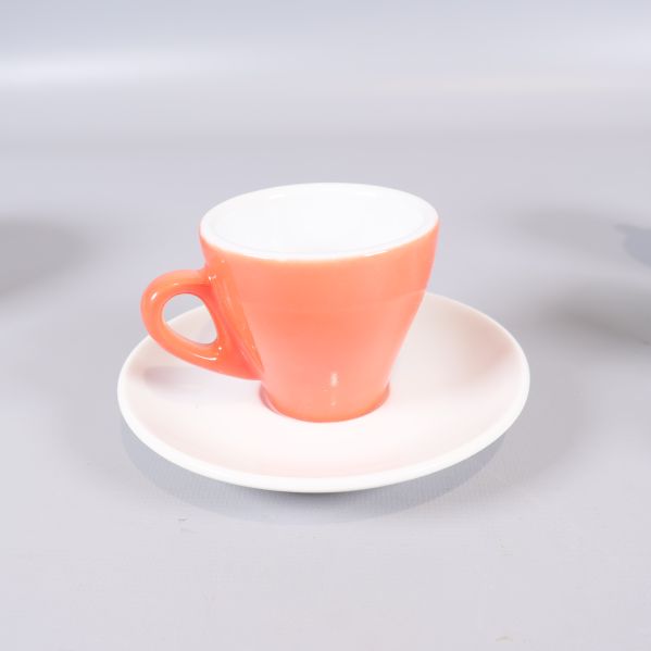 Närbild på espressokopp och fat i korallfärg