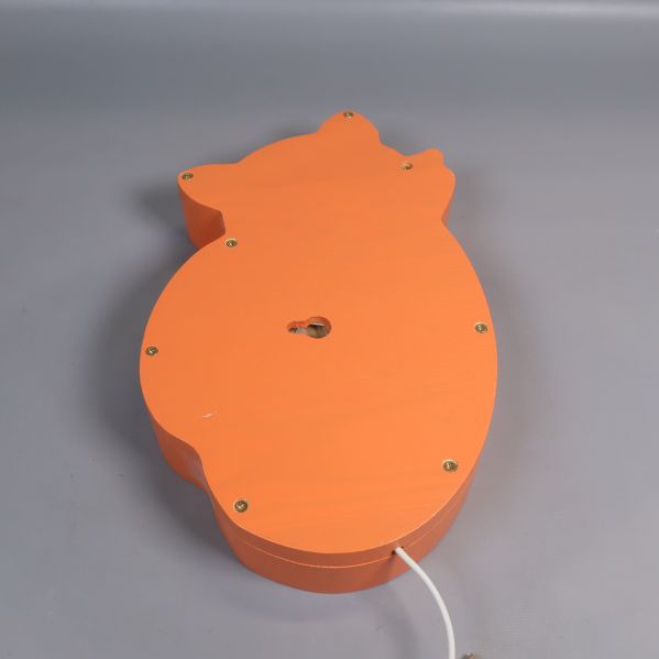 Baksidan på orange rävformad vägglampa med upphängningshål