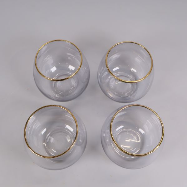Överifrånvy på fyra glas med guldkant ordnade i kvadrat
