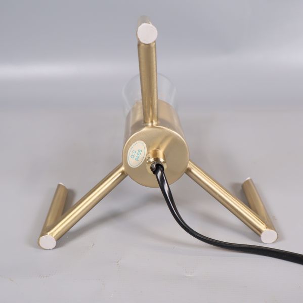 Lampans undersida med svart kabel och runda metallben