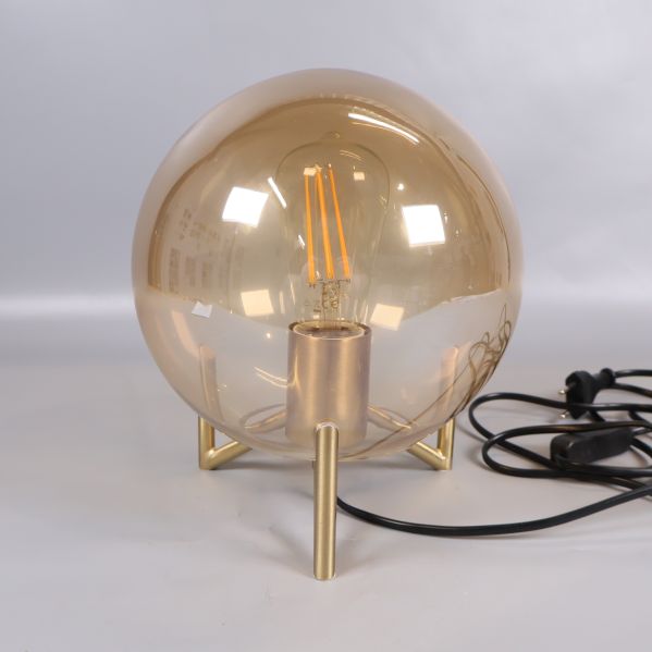 Detalj av glaskupa och synlig ljuskälla på bordslampa
