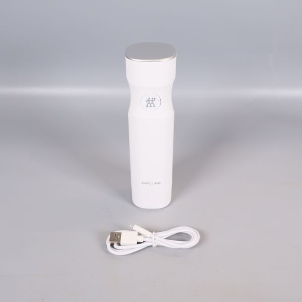 Vit elektrisk vakuumpump med USB-kabel visas separat