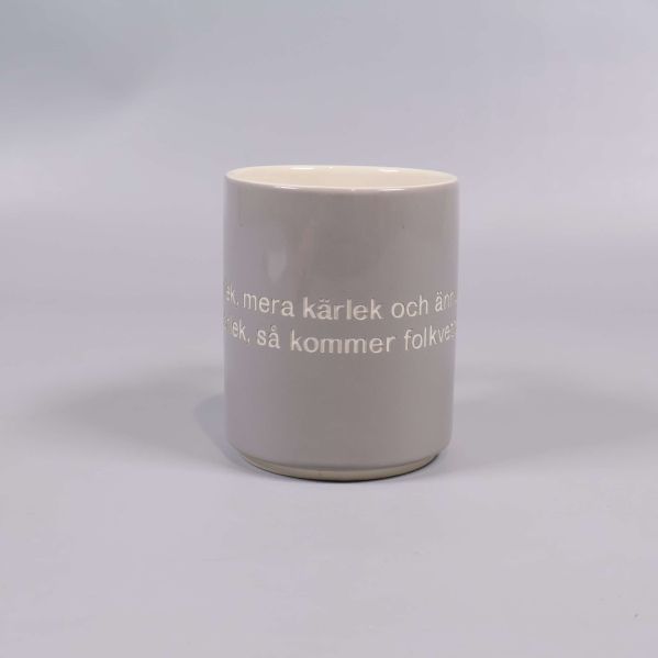 Grå mugg fotograferad rakt framifrån med citat