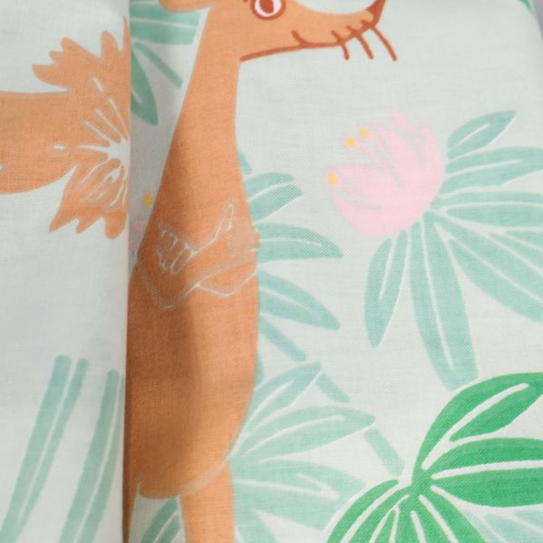 Närbild av örngott med brun figur och gröna blad