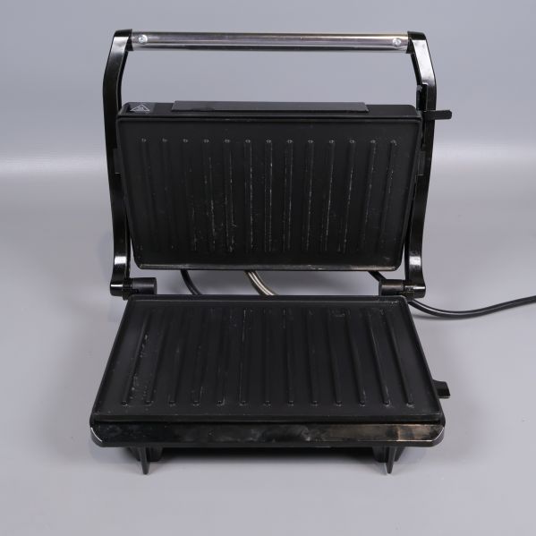Paninigrillen öppen med synliga grillplattor