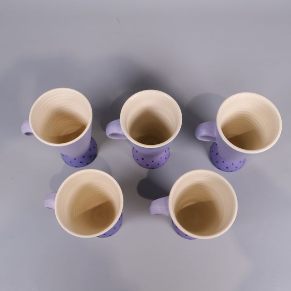 Vy ovanifrån av fem kaffekoppar med ljus insida