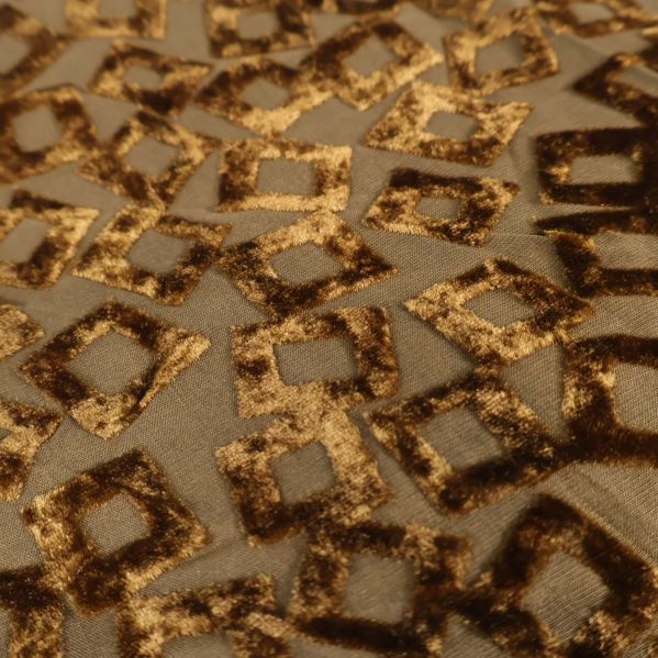 Detalj av geometriskt mönstrad sammet i guld och brunt