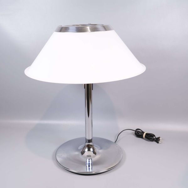 Vit bordslampa med rund metallfot sedd framifrån