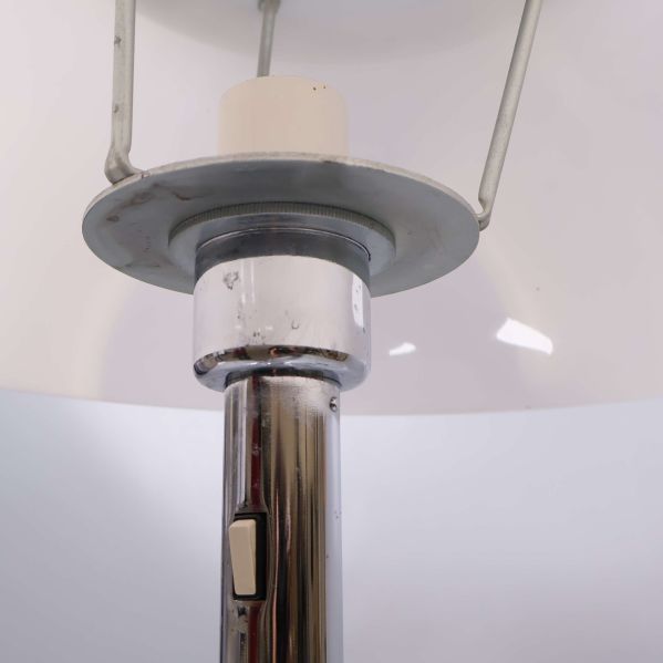 Närbild under lampskärmen på strömbrytare och metalldetaljer