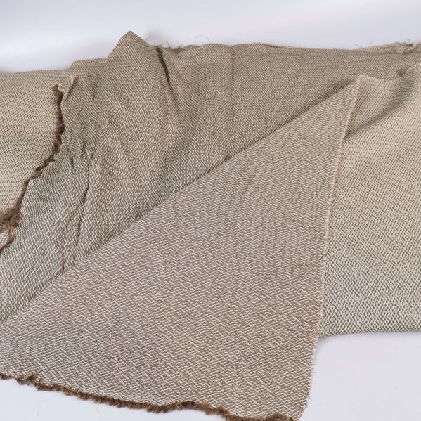 Beige tyg utvikt med synlig struktur och råa kanter