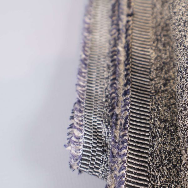 Fransad kant av beige textil syns nära