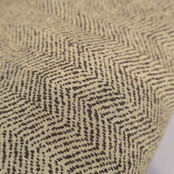 Närbild av tyg med zigzagmönster i beige och brunt