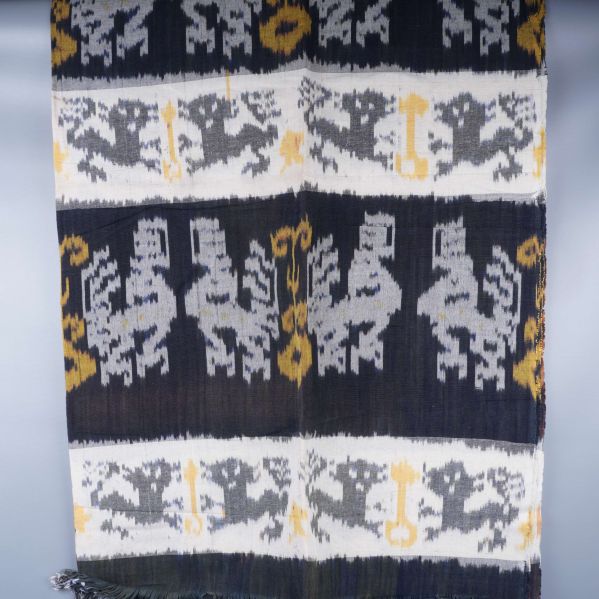 Textil upphängd med upprepade djurmönster och fransar