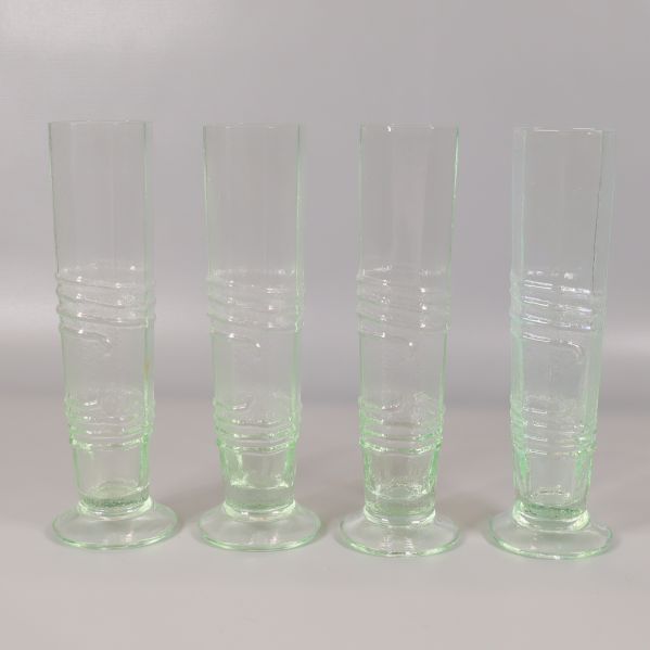 Fyra räfflade ljusgröna glas uppställda i rad