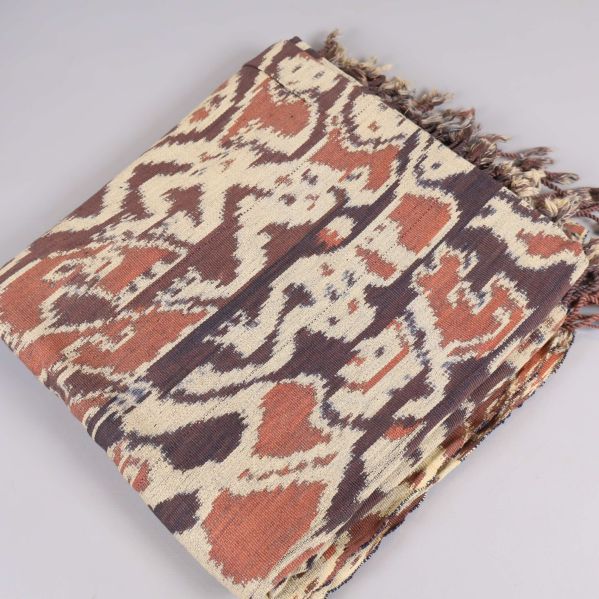 Vikta textilen med brunt och beige etnomönster och fransar