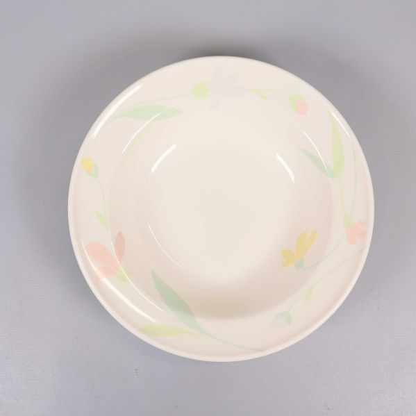 Närbild på djup tallrik med pastellblommor