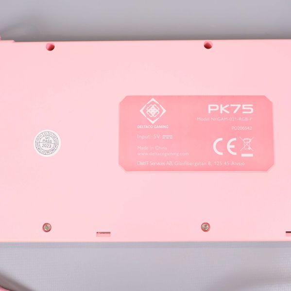 Närbild på etikett under rosa tangentbord med modellinfo
