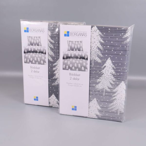 Två förpackade bäddset med granmotiv på grå bakgrund