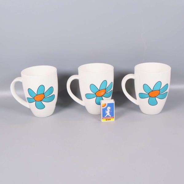 Framsida av tre muggar med stora blommotiv