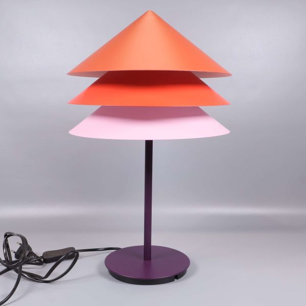 Närbild på bordslampa med tre färgade skärmar och sladd
