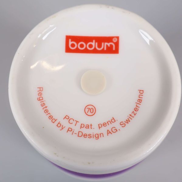 Närbild på botten av mugg med Bodum-logga och text