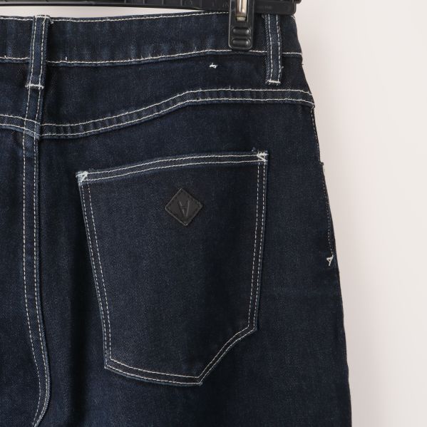 Bakficka av mörka jeans med etikett