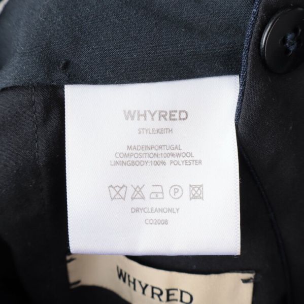 Materialetikett för kostymbyxorna visar ull och polyester