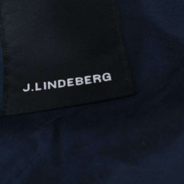 J.Lindeberg logotypen på svart etikett
