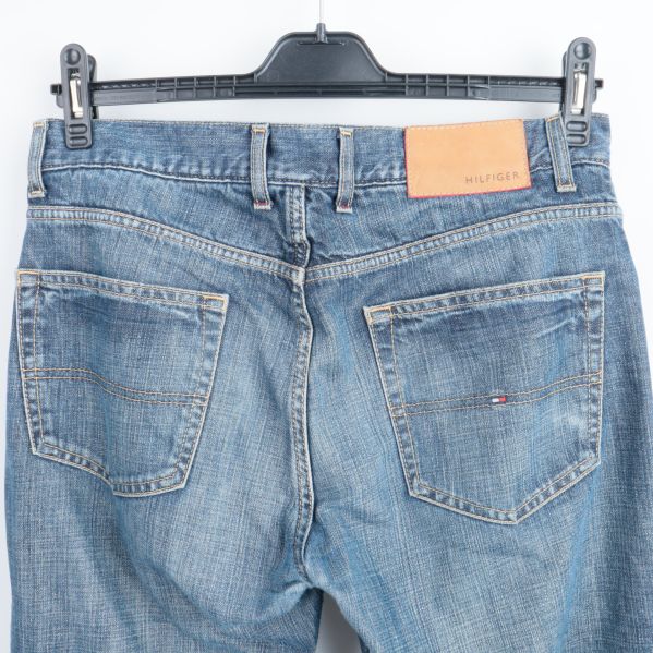 Bakfickor av blå jeans med logotyp