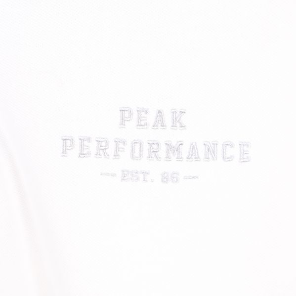 Broderad text på bröstet 'Peak Performance'