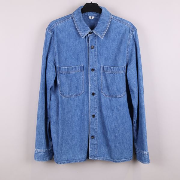 Framsida av blå denimskjorta med fickor