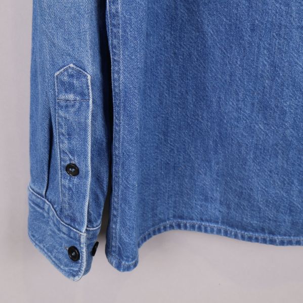 Ärmdetalj med knappar på blå denimskjorta