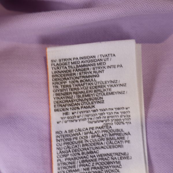 Skötselråd etikett på ljuslila skjorta
