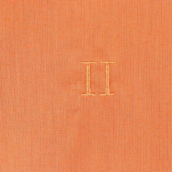 Närbild på broderat emblem på skjortan