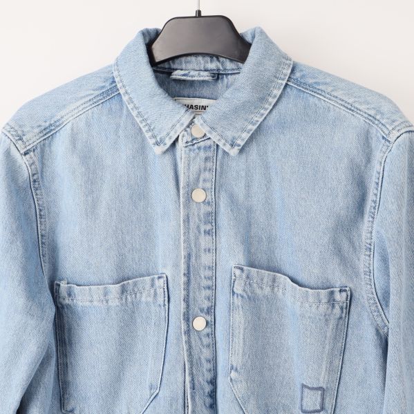 Närbild av krage och fickor på jeansskjortan