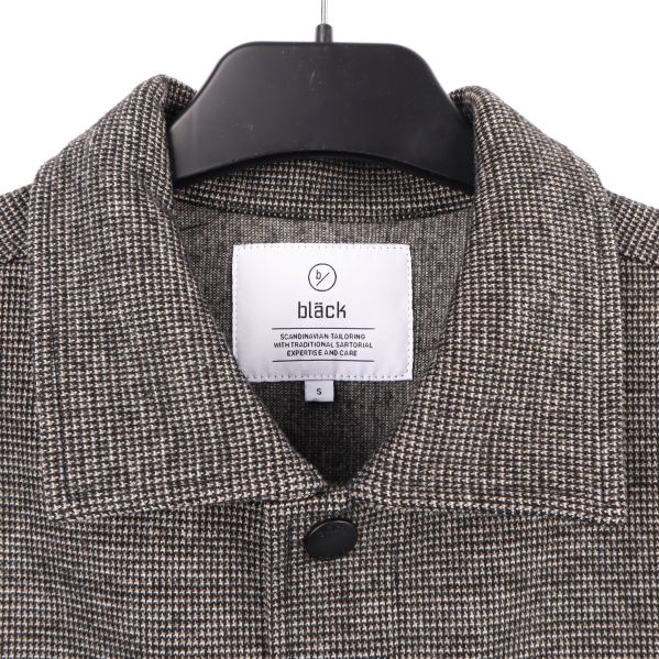 Etikett med märket: Bläck Närbild på skjortans etikett med märket: Bläck